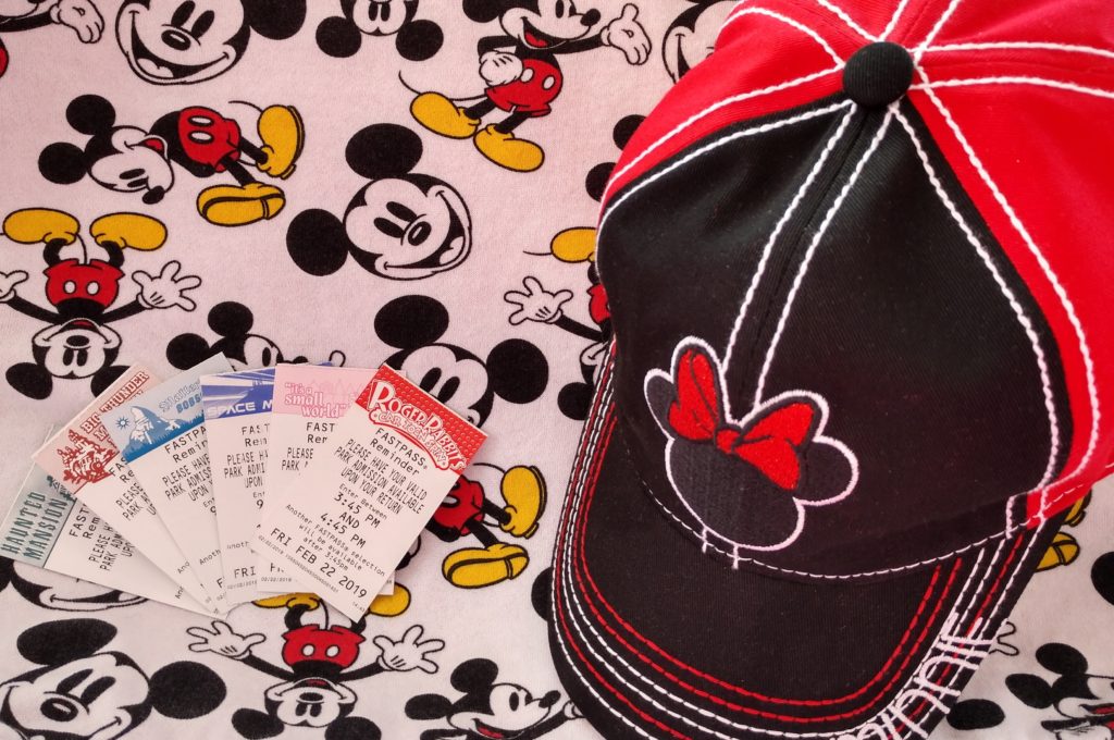 Fastpass reminder tickets next to a Minnie Mouse hat